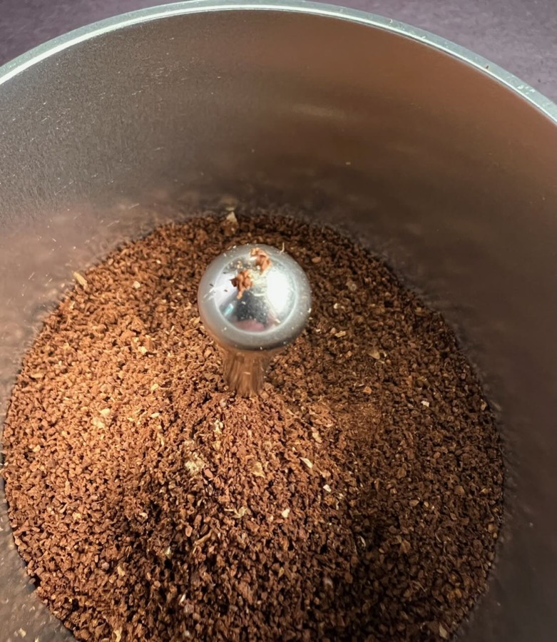 Fresh coffee grounds in the grinder at Black Coffee Cafe